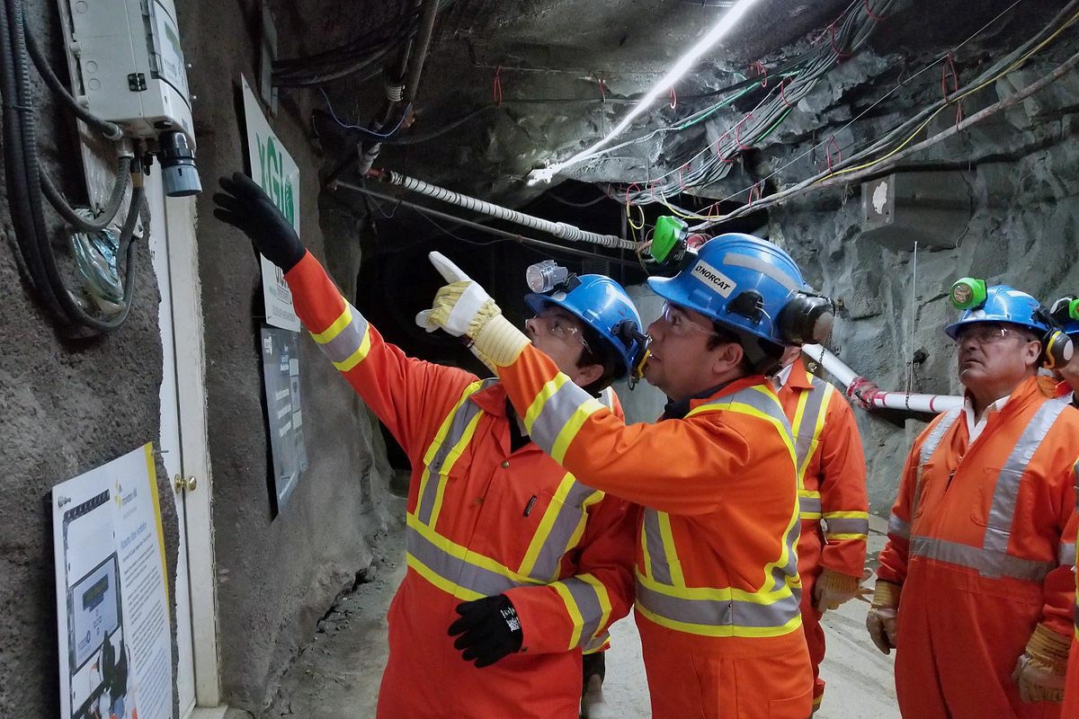 Image of a group of Norcat employees in an underground mine tunnel looking at Maestro's Vigilante Air Quality Station.