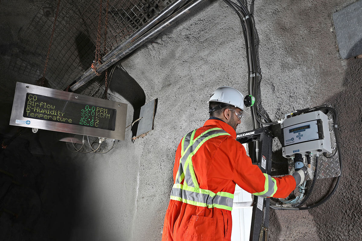 Image of an MDM technician installing the Vigilante AQS underground with the Superbrite marquee in the background